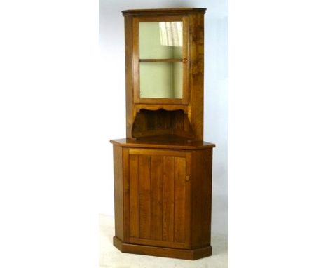 An oak corner cupboard, the glazed top enclosing a single shelf, with a cupboard door below, 85 by 51 by 191cm high.