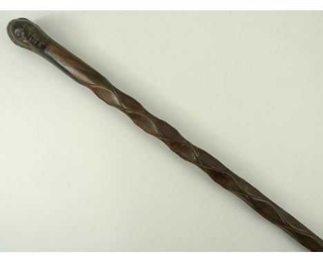 An ebony carved walking stick, from Mozambique, with finely carved head finial and diamond carved shaft, 99cm. 