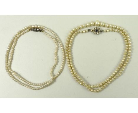 A graduated cultured pearl necklace set on a 9ct gold clasp in the form of a flower, 36cm long, and a further graduated cultu