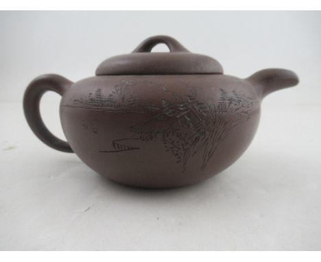 A Chinese Yixing style terracotta teapot, incised with a landscape and script, with seal mark, height 3.75ins&nbsp;Condition 
