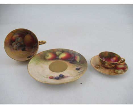 A Royal Worcester tea cup and saucer decorated with fruit by Austin and Price together with a miniature tea cup and saucer by