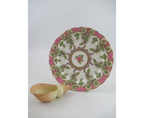 A Royal Worcester plate decorated with foliage to a lattice pink boarder diameter 9ins together with a blush ivory shell Shap