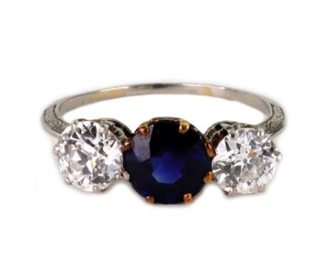 A sapphire and diamond three stone ring, early 20th century, centred by a round mixed-cut sapphire approx. 6.85mm diameter, b