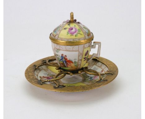 A Berlin porcelain gilt metal mounted inkwell, late 19th century, in the form of a covered cup and saucer, painted with alter