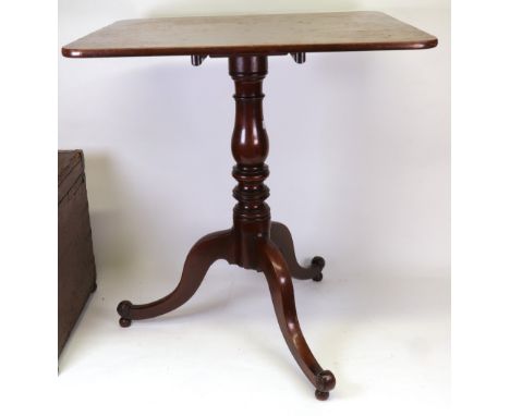 A George III mahogany pedestal table, the rectangular tilt-top on a baluster and ring turned pillar and scrolled tripod base,