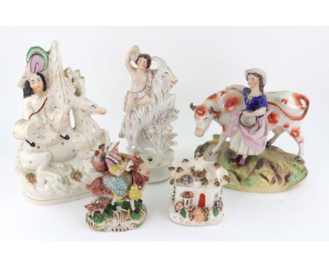 A Staffordshire pottery figure of a Putti on the back of a rearing goat with pen holder base, 23cm high, another of a highlan