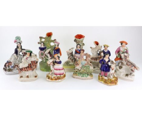 A pair of Staffordshire pottery figures of a boy and a girl standing before goats, with pen holder bases, 14cm high and seven