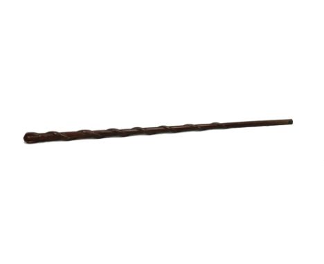 A hardwood walking stick, carved with a clenched fist clasping the head of a snake, its body entwined around the tapering cir