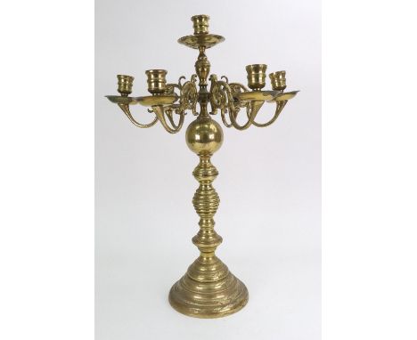 A Dutch brass seven light candleabrum, in 18th century style, with scrolled branches, on a spherical and ring turned pillar a