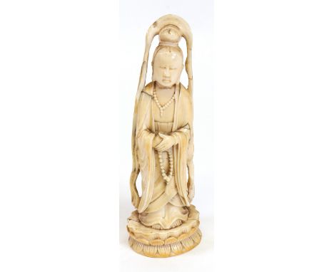 A Chinese carved ivory figure of a guanyin, second half 19th century, standing on a lotus flower, plinth base, 23cm high.