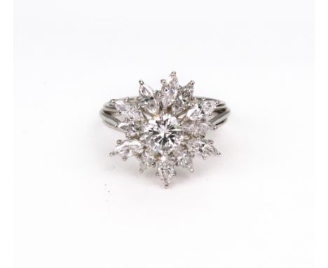 A modern diamond set stylised flowerhead ring, claw set with the central round brilliant cut diamond at the centre, within a 