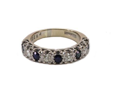 A sapphire and diamond nine stone half eternity ring, the five round mixed-cut dark blue sapphires spaced by small round bril