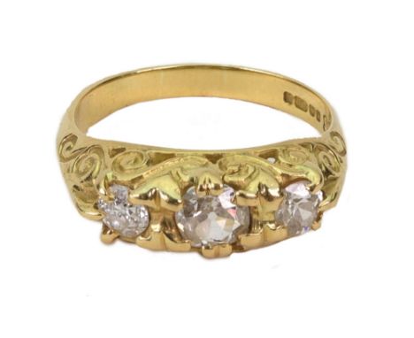 An 18ct yellow gold three-stone diamond ring, in a scroll cast half hoop setting, approx. 1.00ct total, Sheffield 1979, 5g gr