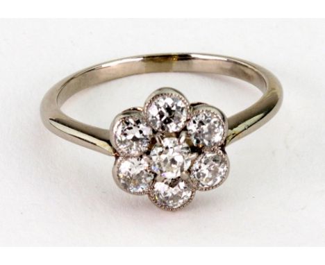 A diamond seven stone 'flower head' cluster ring, early 20th century, set with transition and brilliant-cut stones, approx. 0