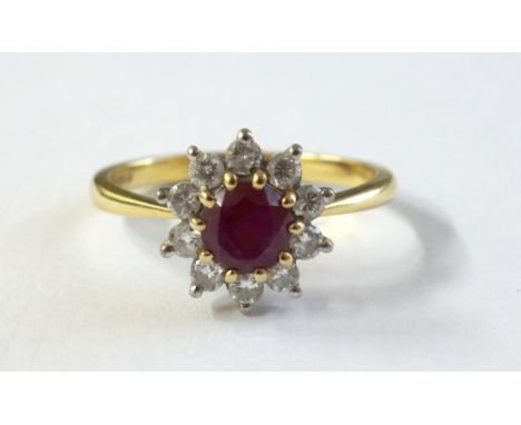 A modern 18ct gold, ruby and diamond cluster ring, centred with a round mixed-cut ruby within a small round brilliant diamond