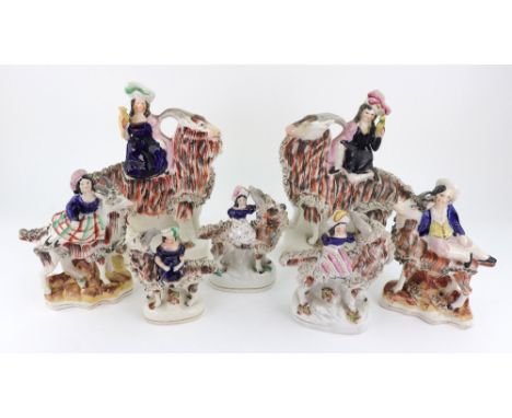 A pair of Staffordshire figures of children kneeling on goats and holding birds, on rectangular bases, 25.5cm high and five o