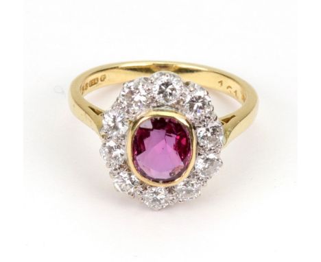 A modern 18ct gold, ruby and diamond oval cluster ring, centred with an oval native-cut ruby, within a round brilliant diamon