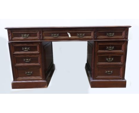 An Edwardian walnut kneehole desk, the moulded rectangular inset top above three frieze and six pedestal drawers, on moulded 