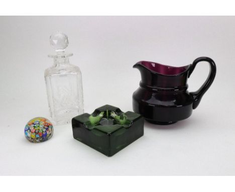 An amethyst glass water jug, bulbous form, with scroll handle, a Stuart square cut glass decanter, a millefiori glass paperwe