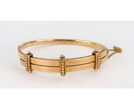 A Victorian hollow gold hinged bangle, circa 1870, of rectangular section, cross-over with three beaded bars, unmarked, value
