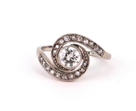 A diamond single stone ring, circa 1930, the round brilliant approx. 0.58cts, rub-over set within a rose diamond white metal 