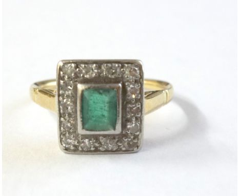 An early 20th century emerald and diamond rectangular cluster ring, centred with a pale step-cut emerald rub-over set in whit