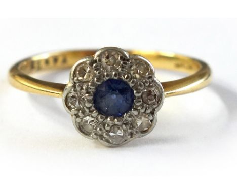 An early 20th century sapphire and diamond flower-head cluster ring, centred with a small round mixed-cut sapphire within a s