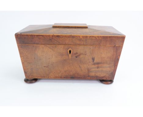 A Regency mahogany tulipwood crossbanded boxwood strung sarcophagus shape tea caddy, with gilt metal lion mask and ring side 