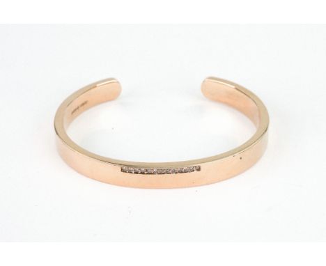 A 9ct rose gold and small diamond thirteen stone torque bangle, London 2012, by Petra, 32.5g gross.