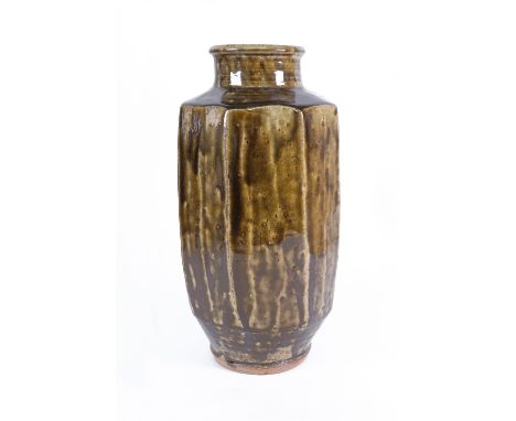 Leach Pottery, a six-sided stoneware vase with circular rim and foot in a runny olive brown pooling glaze, 30cm high, impress