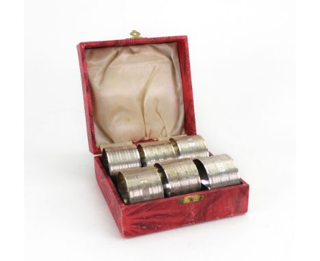 A cased set of six engine turned circular napkin rings, detailed silver, initialled, 'C', 7ozs.