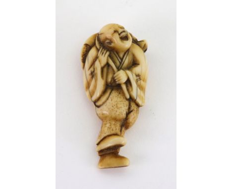 A ivory netsuke, probably 18th century, carved as a fisherman carrying a turtle across his back, 5.5cm wide.Illustrated.