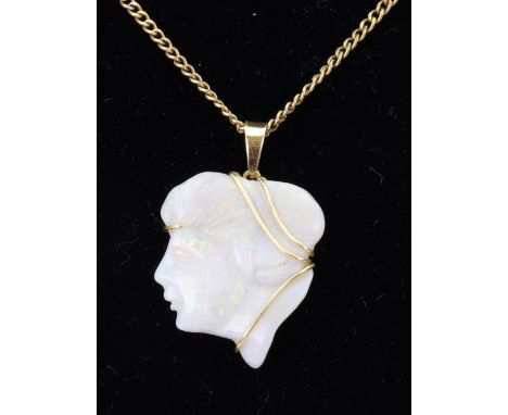 A carved white opal pendant, modelled as a female head in profile, set in yellow metal stamped '18ct' on a neck chain, stampe