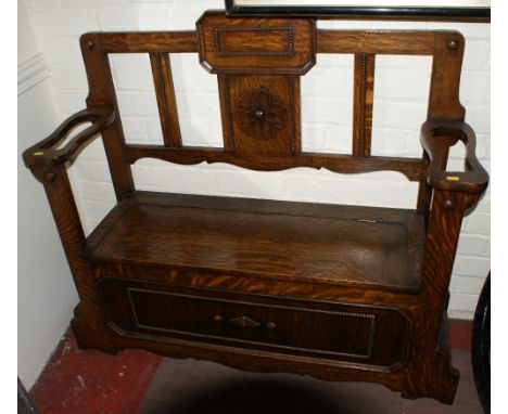 Oak hall settle with storage box seat floral and bead decoration and arm rests incorporating umbrella and stick stands. 122 c