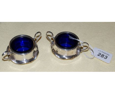 A pair of two-handled silver salts with blue glass liners. Maker M. Bros. (Mappin Brothers). Hall marked Birmingham 1905 (sil