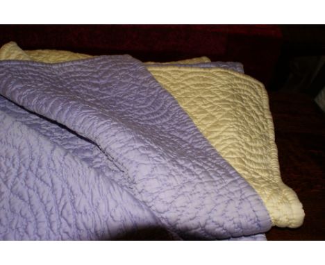 Vintage hand-stitched Durham quilt with stylised floral pattern on one side violet, the other plain yellow