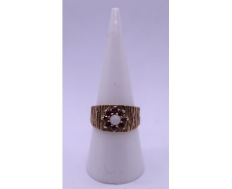 Vintage bark effect 9ct gold ring with central white opal surrounded by 7 garnets. Size O - Approx gross weight 3.7g 