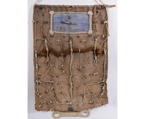 A ropework and canvas display panel from the Steam Salvage Tug 'Superman':, having ship's crest over painted portrait and rop