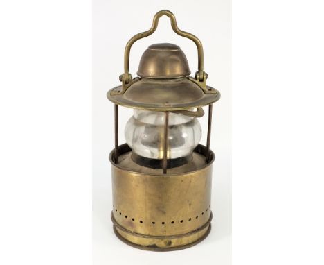 A circular brass ship's lamp:, the shaped swing handle over domed cover and baluster lens with sliding shade, later electrica