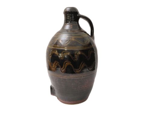 A large Winchcombe Pottery stoneware flagon: the handle affixing to a baluster-shaped body, slip decorated with undulating co
