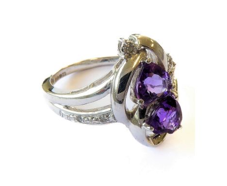 A hallmarked-silver dress ring vertically set with two-shaped amethysts surrounded by small diamonds in a pierced crossover-s