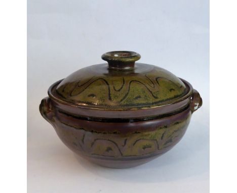 A large, two-handled Winchcombe pottery casserole and cover of circular form: the domed-topped cover decorated with concentri