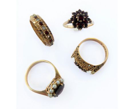 Four 9-carat yellow gold garnet-set rings: a tiered cluster; a cluster with seed pearl border; an alternate garnet and white 