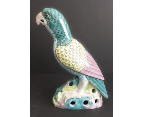 A&nbsp;Kangxi-style porcelain parrot decorated in greens, yellows and blues upon a reticulated rockwork base, probably 19th c
