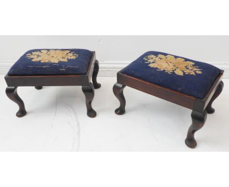 A pair of early 20th century walnut framed stools in earlier 18th century style: each with floral tapestry drop-in seat above