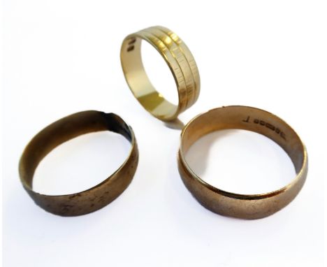 An 18-carat yellow gold engraved wedding band (ring size M/N, weight 3.7g), together with two 9-carat yellow gold plain weddi