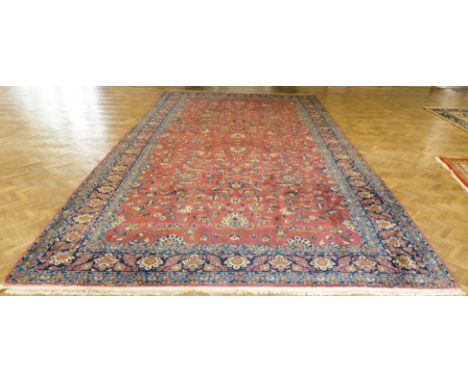 A large and fine North West Persian Sarouk (Kelleh) carpet: rose red field with an overall design of scrolling flowers and pa