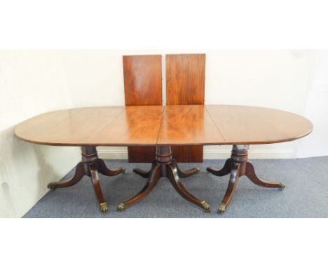 A large and impressive three-pillar early 19th century mahogany dining table with two extra leaves: each pillar with gun-barr