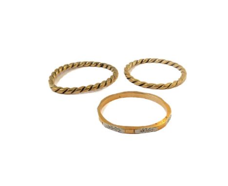 A 22-carat two-coloured gold wedding band, together with two rope-twist bands (ring size L, combined gross weight 4.3g) (3)Co