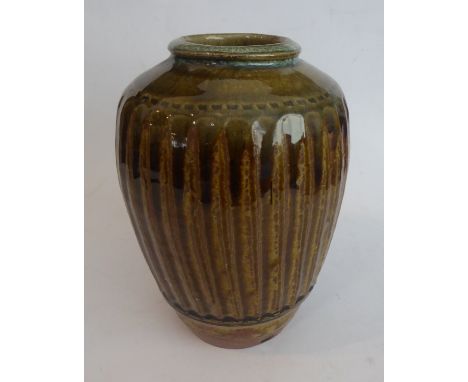 A studioware, stoneware vase (probably Winchcombe Pottery) or fluted, baluster form and with a mottled brown/mustard glaze, i